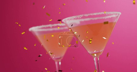 Image of confetti falling and cocktails on pink background. Party, drink, entertainment and celebration concept digitally generated image.