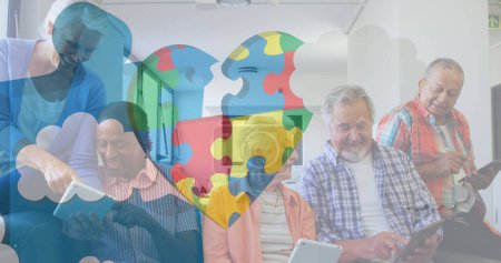 Photo for Image of colourful puzzle pieces heart over senior friends using electronic devices. autism, learning difficulties, support and awareness concept digitally generated image. - Royalty Free Image