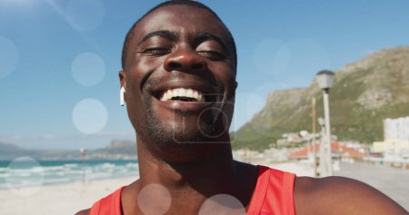 Photo for Image of glowing lights over happy exercising african american man making image call and waving. Global connections, wellbeing, fitness and healthy lifestyle concept digitally generated image. - Royalty Free Image