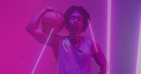 Photo for Image of confetti and neon pattern and biracial basketball player. Sports, competition, image game and communication concept digitally generated image. - Royalty Free Image