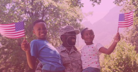 African american father in soldier uniform carrying his son and daughter in the garden. family, love and togetherness concept
