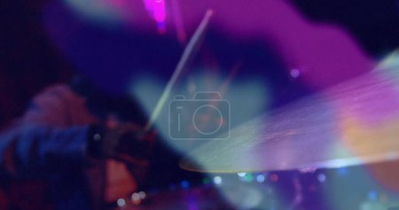 Foto de Imagen de luces de colores borrosas sobre el hombre afroamericano tocando el kit de batería en cámara lenta. Música en vivo, creatividad, performance y concepto de entretenimiento imagen generada digitalmente. - Imagen libre de derechos
