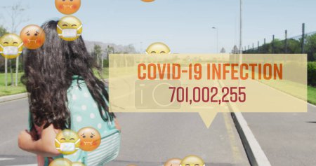 Téléchargez les photos : Image de covide 19 numéros d'infection et emojis avec écolier masqué traversant la route. Soins de santé et protection lors d'une pandémie de coronavirus covid 19, image générée numériquement. - en image libre de droit