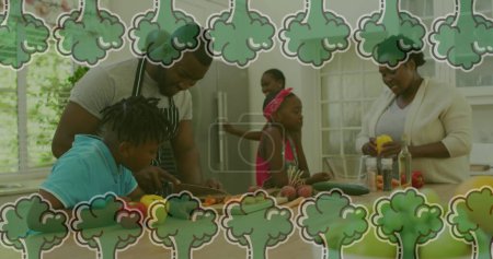 Foto de Imagen de verduras cayendo sobre la familia afroamericana cocinando juntas en la cocina. tiempo de calidad familiar, cocina y concepto de alimentos imagen generada digitalmente. - Imagen libre de derechos