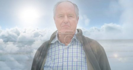 Photo for Image of glowing light over serious senior man over clouds. retirement and happy senior life concept digitally generated image. - Royalty Free Image