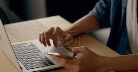 Photo for Midsection of man texting on smartphone and using laptop at desk. global connection and technology concept digitally generated image. - Royalty Free Image