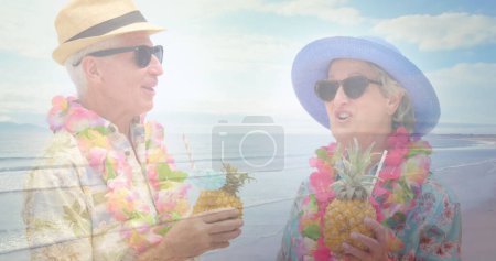 Photo for Image of glowing light over happy senior couple having cocktails by seaside. retirement and senior life concept digitally generated image. - Royalty Free Image