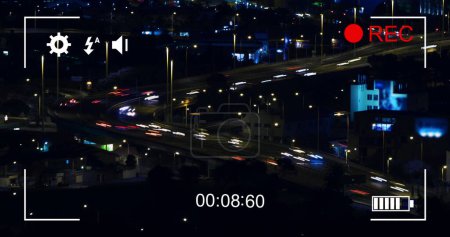 Image of night traffic in fast motion and cityscape, seen on a screen of a digital camera in record mode with icons and timer 4k