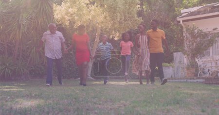 Téléchargez les photos : Famille afro-américaine de trois générations se tenant la main demandant ensemble dans le jardin. concept de famille, d'amour et de solidarité - en image libre de droit