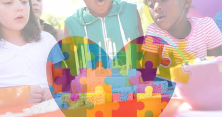 Photo for Image of colourful puzzle pieces and heart over kids friends on birthday. autism, learning difficulties, support and awareness concept digitally generated image. - Royalty Free Image