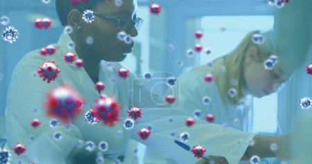 Foto de Imagen de células del coronavirus que fluyen sobre dos trabajadoras de laboratorio que examinan muestras de sangre. Covid 19 pandemia salud ciencia medicina concepto digital compuesto. - Imagen libre de derechos