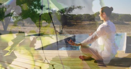 Téléchargez les photos : Image de feuilles sur femme caucasienne pratiquant le yoga et la méditation. Journée mondiale de méditation et concept de célébration image générée numériquement. - en image libre de droit