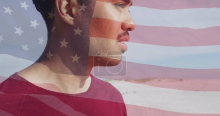 Téléchargez les photos : Image du drapeau des États-Unis d'Amérique et de l'homme biracial sur la plage. Patriotisme américain, diversité et concept de tradition image générée numériquement. - en image libre de droit
