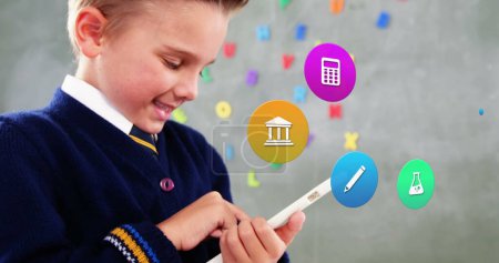 Bild von bunten Ikonen über kaukasischen Schuljungen mit Tablet. Globale soziale Medien, Icons und digitales Interface-Konzept digital generiertes Bild.