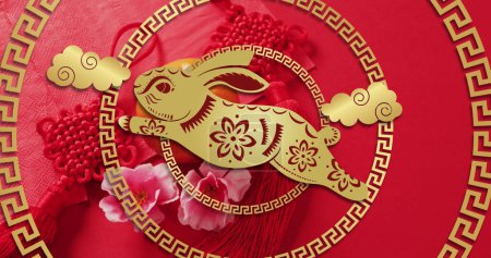 Image of chinese pattern and rabbit year decoration on red background. Chinese new year, festivity, celebration and tradition concept digitally generated image.