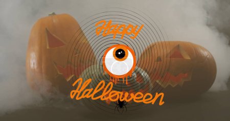 Foto de Feliz pancarta de texto de Halloween con el icono del ojo de miedo contra el efecto de humo sobre las calabazas. Halloween festividad y concepto de celebración - Imagen libre de derechos