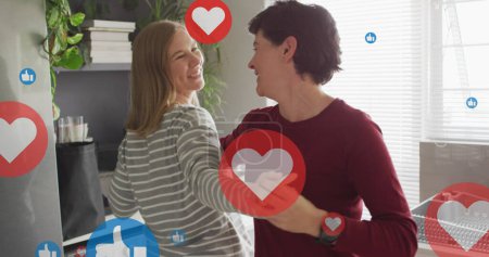 Photo for Image of hearts and like icons over caucasian female couple dancing. Valentines, love and celebration concept digitally generated image. - Royalty Free Image