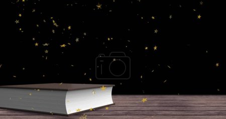 Téléchargez les photos : Image d'étoiles d'or tombant sur un livre sur une surface en bois. Journée internationale de l'alphabétisation et concept de lecture image générée numériquement. - en image libre de droit