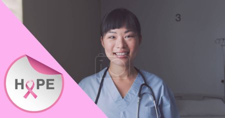 Foto de Imagen de texto de cáncer de mama rosa sobre una doctora sonriente. imagen generada digitalmente del concepto de campaña de concienciación positiva del cáncer de mama. - Imagen libre de derechos