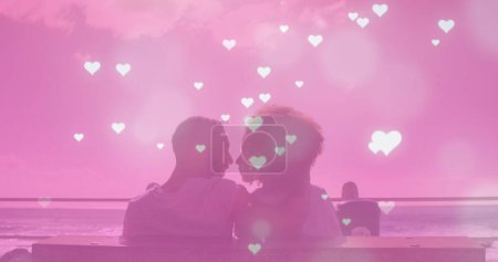 Multiple glowing heart icons falling over african american couple kissing each other at the beach. Love and relationship concept