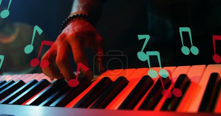 Image of notes moving over caucasian man playing keyboard. creative month and celebration concept digitally generated image.