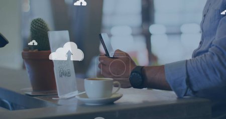 Téléchargez les photos : Icônes Cloud contre la partie médiane d'un homme caucasien numérisant le code qr avec son smartphone dans un café. paiement numérique et concept technologique - en image libre de droit