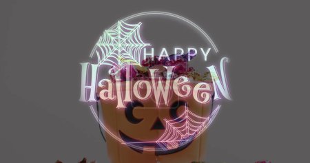 Téléchargez les photos : Bannière texte Halloween avec icône de toile d'araignée contre seau en forme de citrouille plein de bonbons d'Halloween. fête d'Halloween et concept de célébration - en image libre de droit