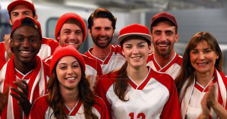 Téléchargez les photos : Vue de face d'un groupe de fans de sport portant des maillots rouges et blancs acclamant - en image libre de droit