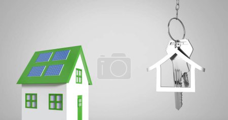 Téléchargez les photos : Image de clés de maison en argent et porte-clés en forme de maison suspendus sur une maison verte et blanche sur fond gris 4k - en image libre de droit