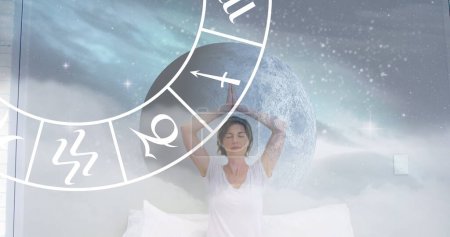 Photo for Circle of zodiac signs over caucasian women practicing yoga. Horoscope, yoga meditation concept digitally generated image. - Royalty Free Image