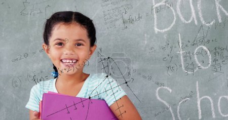 Foto de Imagen de fórmulas matemáticas sobre la feliz niña birracial sosteniendo libros. aprendizaje, educación y concepto escolar imagen generada digitalmente. - Imagen libre de derechos
