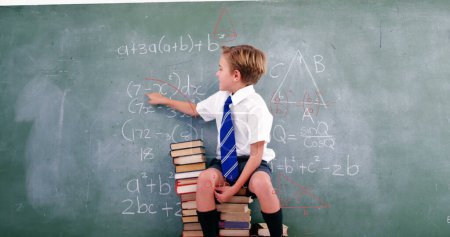 Téléchargez les photos : Image de formes géométriques sur un garçon caucasien écrit sur un tableau noir. apprentissage, éducation et concept scolaire image générée numériquement. - en image libre de droit