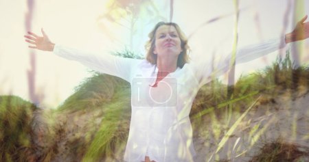 Téléchargez les photos : Image d'une femme caucasienne avec les bras tendus sur la plage. ne jamais abandonner le concept de jour et de célébration, image générée numériquement. - en image libre de droit