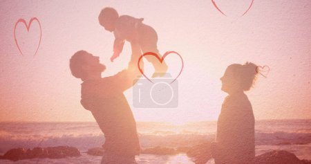 Foto de Imagen de corazones cayendo sobre la familia caucásica en la playa. concepto de moda y estilo de vida, imagen generada digitalmente. - Imagen libre de derechos