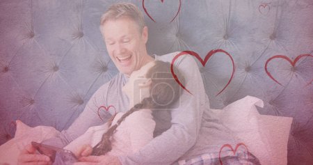 Photo for Image of hearts falling over caucasian man and his daughter using tablet. fashion and lifestyle concept, digitally generated image. - Royalty Free Image