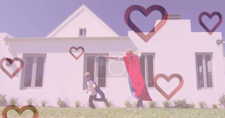 Téléchargez les photos : Image de cœurs tombant sur une femme caucasienne et son fils jouant ensemble dans un jardin. mode et style de vie concept, image générée numériquement. - en image libre de droit
