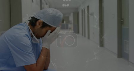 Photo for Image of moving spiral over sad biracial male nurse in hospital. mental health awareness week and celebration concept, digitally generated image. - Royalty Free Image