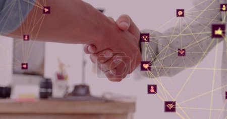 Image of network of connections with icons over diverse business people shaking hands. national handshake day, global business and digital interface concept, digitally generated image.