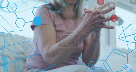 Photo for Image of medical icons and molecules over senior caucasian woman disinfecting hands. medical and healthcare services concept, digitally generated image. - Royalty Free Image