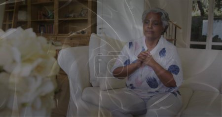 Image of moving shapes over sad senior african american woman. mental health awareness week and celebration concept, digitally generated image.