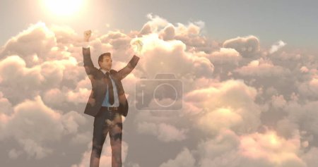 Téléchargez les photos : Image d'un homme d'affaires biracial les bras tendus sur le ciel avec des nuages. ne jamais abandonner le concept de jour et de célébration, image générée numériquement. - en image libre de droit