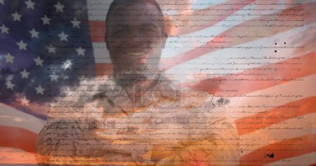 Téléchargez les photos : Image numérique d'une constitution écrite des États-Unis se déplaçant à l'écran avec un fond montrant le ciel avec des nuages. Un drapeau américain flotte derrière un militaire afro-américain en uniforme - en image libre de droit