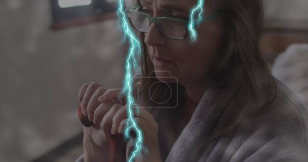 Photo for Image of lightning over sad senior caucasian woman with cane. mental health awareness week and celebration concept, digitally generated image. - Royalty Free Image