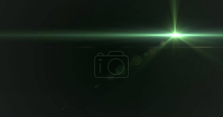 Photo for Green light beam crossing dark background, creating lens flare. Description evokes sense of mystery or futuristic technology, captivating viewers with its simplicity and depth - Royalty Free Image