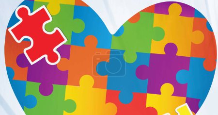Image of heart of puzzle over puzzle pieces. Autism awareness month and digital interface concept digitally generated image.