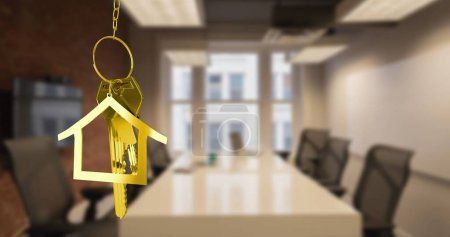 Image of hanging golden house keys against interior of a office conference room. Interior designing and real estate concept
