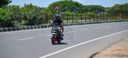 Photo for Viluppuram, India: August 28th 2022: Young Couple Long Drive Travel on Indian National Highway Road Travel. High speed two wheelers vehicle on Indian Road Highways, Vehicle on Indian Road . - Royalty Free Image