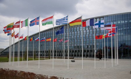 Foto de Las banderas nacionales de los países miembros de la OTAN ondean fuera de la sede de la organización en Bruselas, Bélgica, el 20 de abril de 2023.. - Imagen libre de derechos