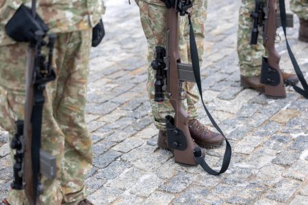 Las piernas de un soldado de camuflaje lituano y su rifle