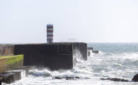 Leuchtturm auf einem Strand in Porto City Portugal Strand mit dramatischen Wellen des Atlantischen Ozeans